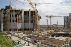 View of a bustling urban construction site with cranes and high-rise buildings.